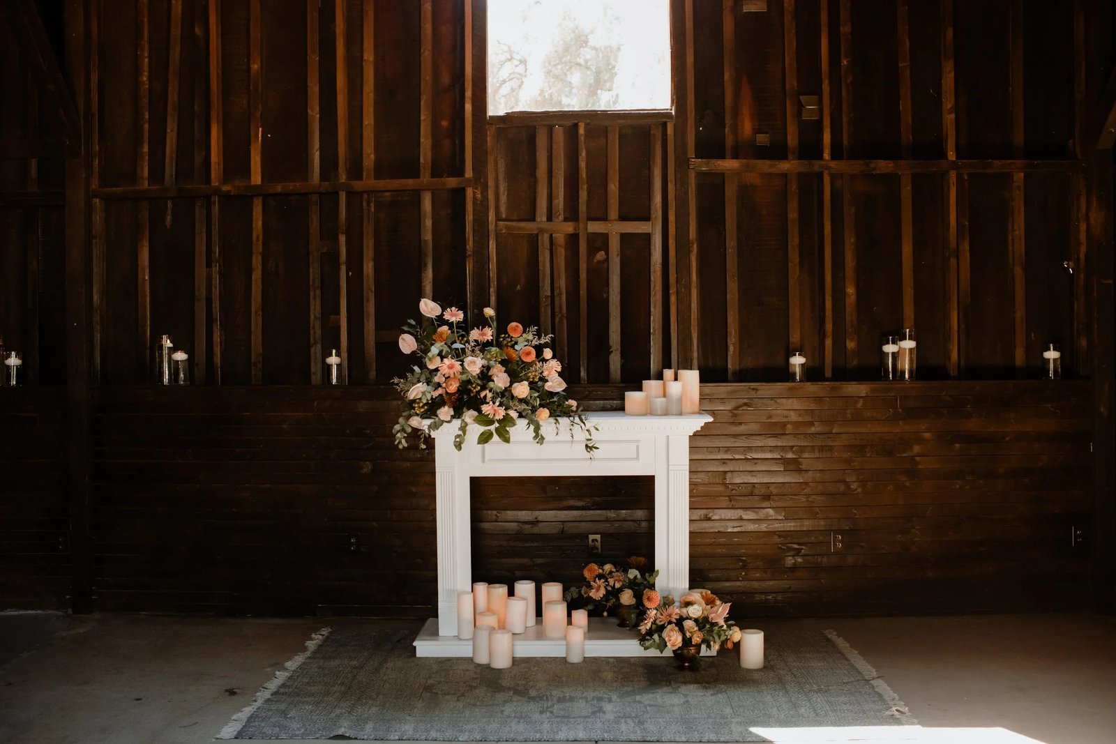 Candlelit barn ceremony backdrop with florals