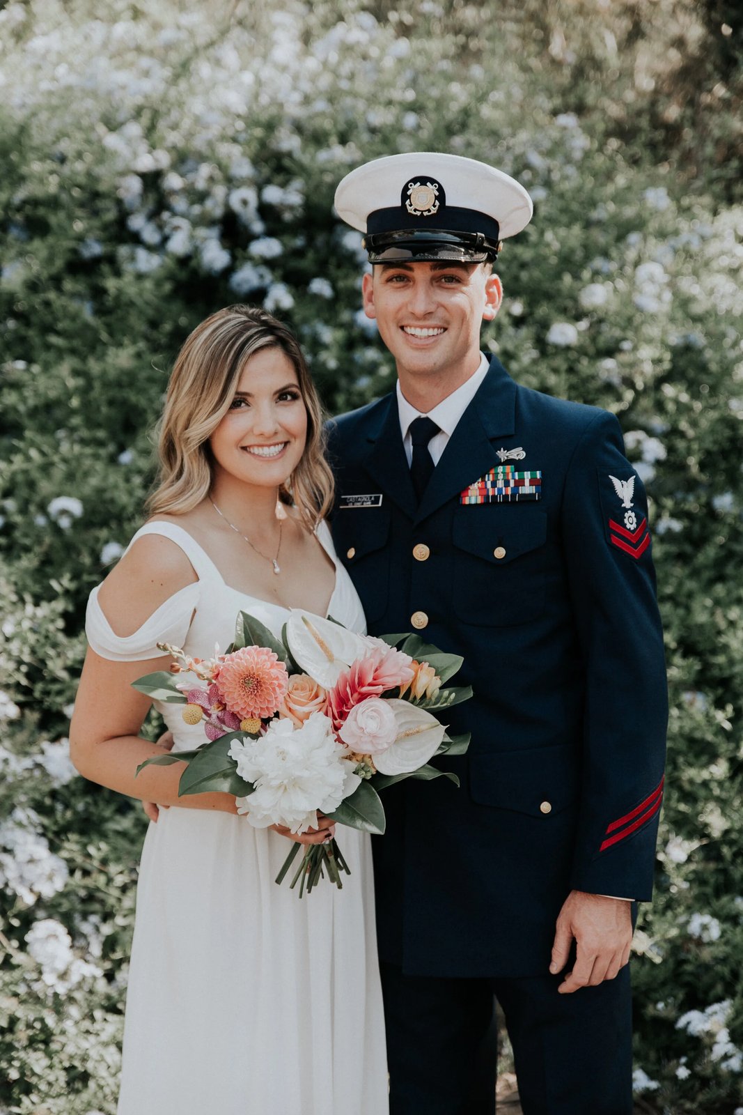 Bride with a soft pink bouquet at a floral wall
